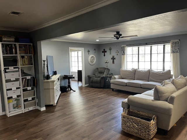 living room featuring crown molding, dark wood-type flooring, visible vents, and ceiling fan