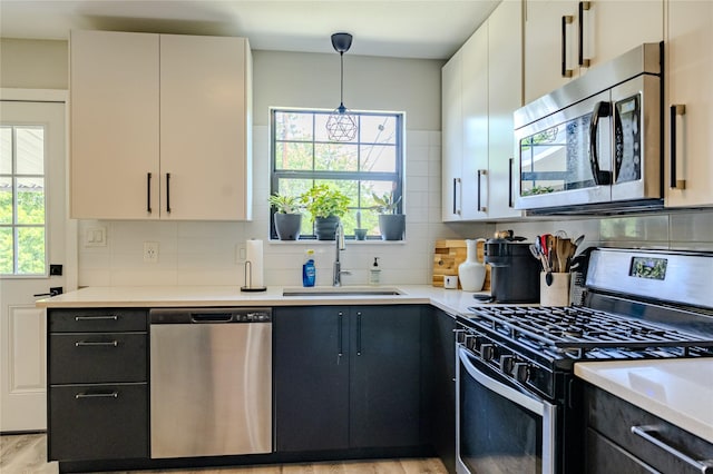 kitchen with a sink, light countertops, tasteful backsplash, and stainless steel appliances