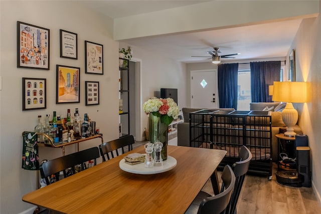 dining room with baseboards, ceiling fan, and wood finished floors