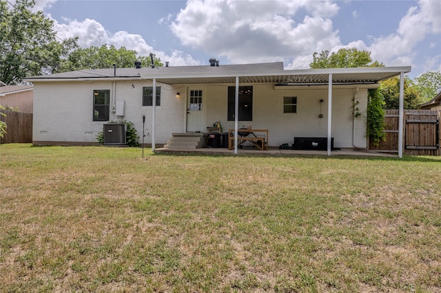 rear view of house with a lawn, brick siding, fence, and central air condition unit