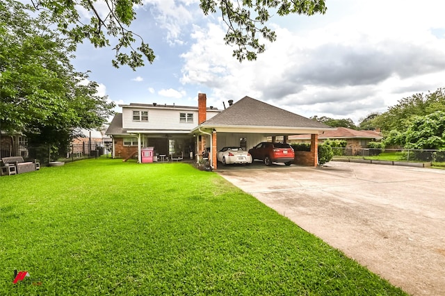 exterior space featuring driveway, a chimney, fence, a yard, and an attached carport