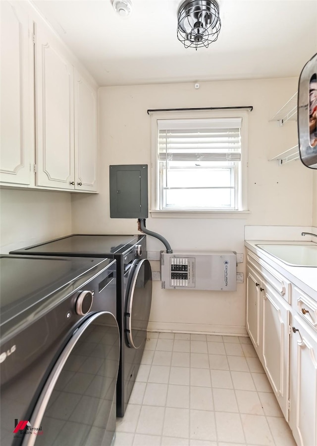 clothes washing area featuring cabinet space, a sink, light tile patterned floors, washer and clothes dryer, and electric panel