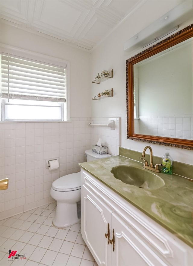 half bath featuring tile walls, tile patterned floors, vanity, and toilet