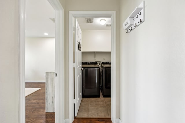 hall featuring washing machine and clothes dryer and visible vents