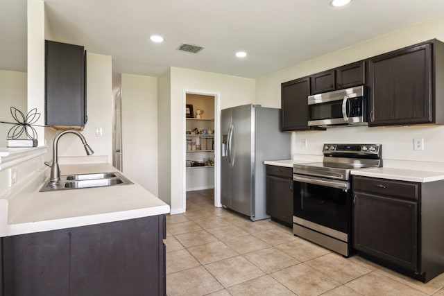 kitchen featuring visible vents, light countertops, a sink, appliances with stainless steel finishes, and light tile patterned floors
