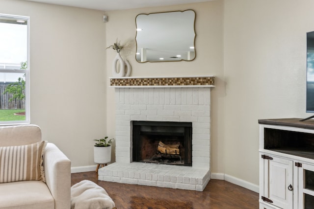 living area with baseboards, wood finished floors, and a fireplace