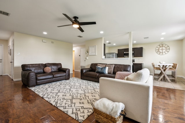 living area featuring baseboards, ceiling fan, wood-type flooring, and visible vents