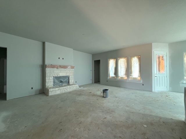 unfurnished living room with a stone fireplace