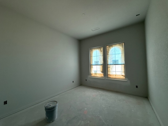unfurnished room featuring baseboards and concrete floors