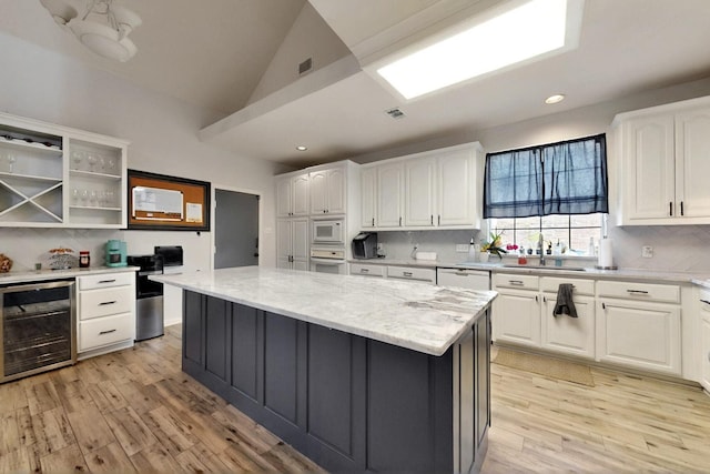 3017 Holford Rd, Richardson, TX 75082 - kitchen featuring beverage cooler, white appliances, a sink, light wood finished floors, and white cabinets