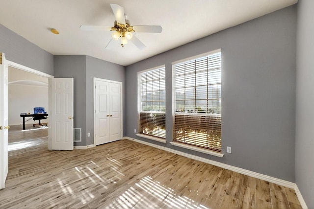 3017 Holford Rd, Richardson, TX 75082 - unfurnished bedroom featuring baseboards, wood finished floors, a closet, and arched walkways