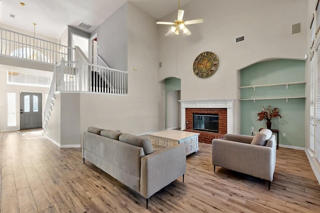 3017 Holford Rd, Richardson, TX 75082 - living area with a towering ceiling, ceiling fan, light wood finished floors, stairway, and baseboards