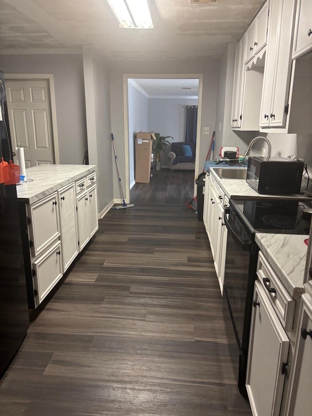 kitchen featuring light stone countertops, white cabinetry, baseboards, black / electric stove, and dark wood-type flooring