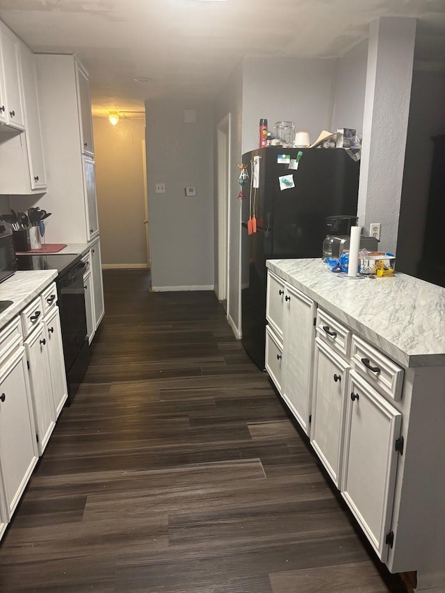 kitchen with freestanding refrigerator, white cabinetry, dark wood finished floors, and light countertops
