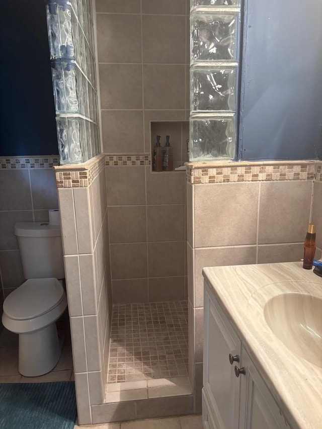 bathroom featuring walk in shower, tile walls, tile patterned flooring, and vanity