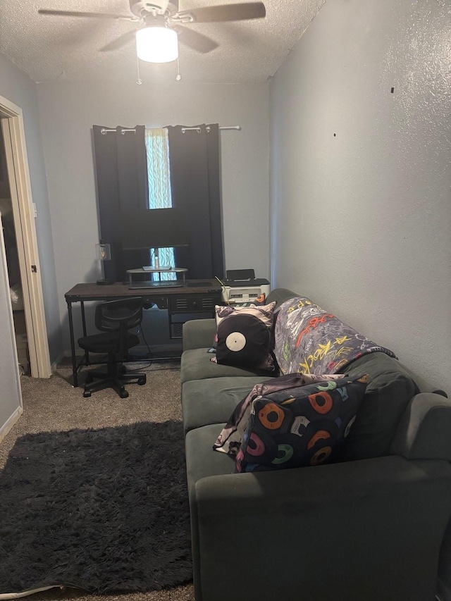 carpeted living area featuring a ceiling fan and a textured ceiling