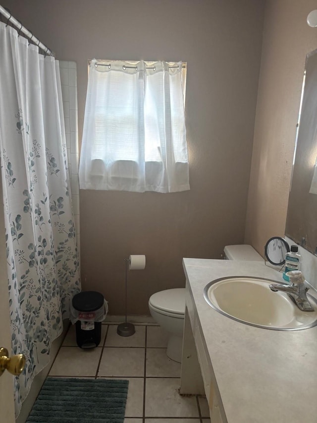 bathroom with toilet, a shower with curtain, tile patterned flooring, and vanity