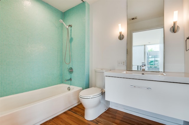 bathroom with shower / tub combination, vanity, toilet, wood finished floors, and visible vents