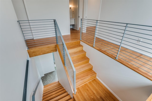 stairs with baseboards and wood finished floors