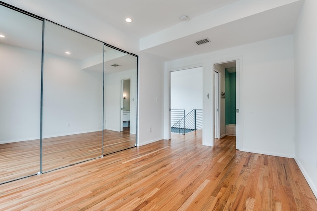 unfurnished bedroom with visible vents, light wood-type flooring, baseboards, a closet, and recessed lighting