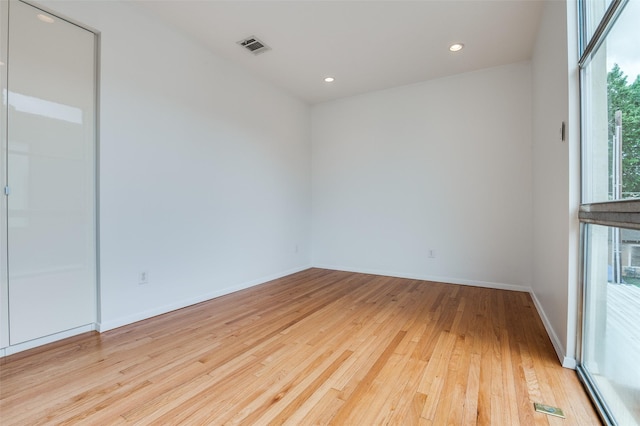 spare room featuring recessed lighting, baseboards, light wood-type flooring, and visible vents