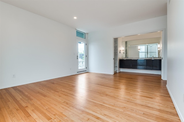 unfurnished living room with baseboards, recessed lighting, and wood finished floors