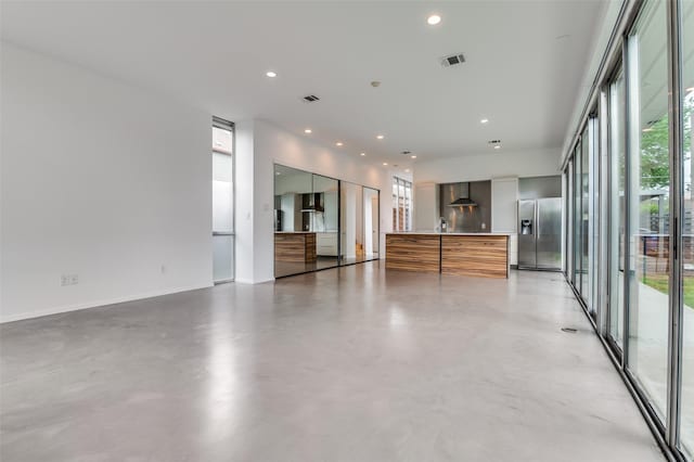 empty room featuring baseboards, concrete flooring, recessed lighting, and visible vents