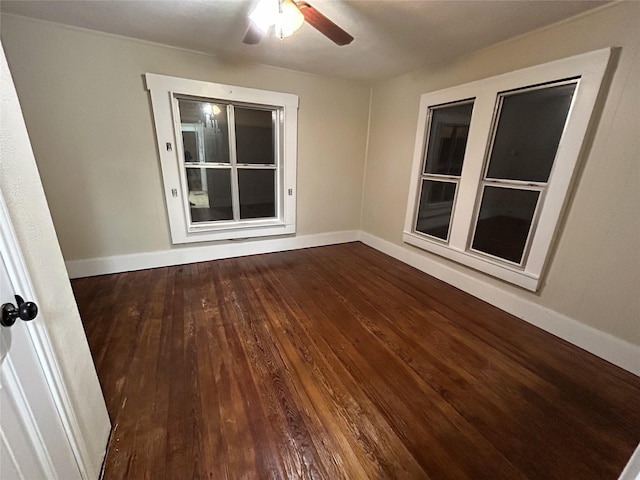 empty room featuring baseboards, a ceiling fan, and wood finished floors