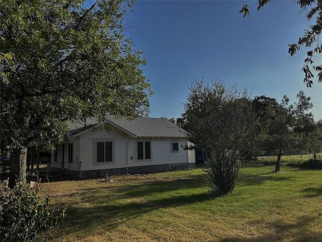 view of side of home with a lawn