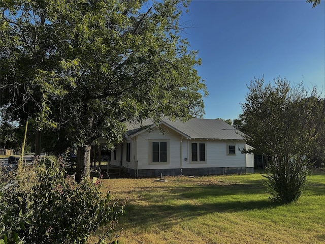 view of side of home with a lawn