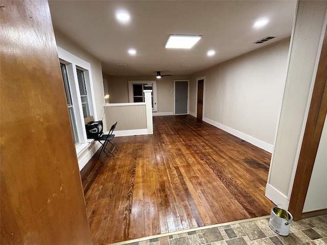 interior space featuring baseboards, hardwood / wood-style floors, and visible vents