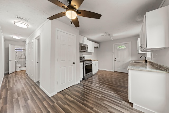 2301 Connor Ave, Waco, TX 76706 - kitchen with a sink, dark wood finished floors, stainless steel appliances, baseboards, and visible vents