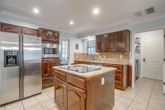 7116 Westover Dr, Granbury, TX 76049 - kitchen with decorative backsplash, appliances with stainless steel finishes, a center island, light tile patterned floors, and a sink