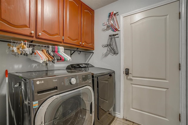 7116 Westover Dr, Granbury, TX 76049 - laundry room with cabinet space, light tile patterned flooring, and washing machine and clothes dryer