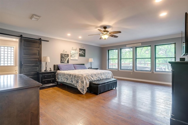 7116 Westover Dr, Granbury, TX 76049 - bedroom featuring visible vents, crown molding, wood finished floors, recessed lighting, and a barn door