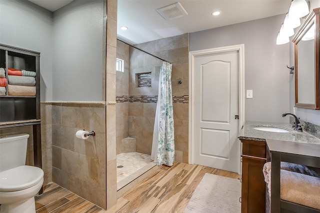 7116 Westover Dr, Granbury, TX 76049 - bathroom featuring visible vents, vanity, wood finished floors, toilet, and tiled shower