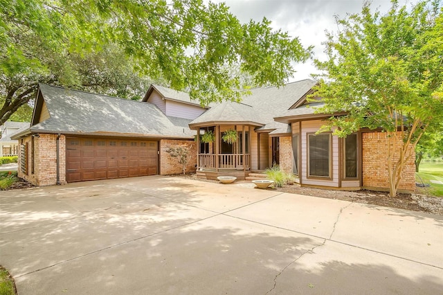 7116 Westover Dr, Granbury, TX 76049 - view of front of home featuring concrete driveway, brick siding, an attached garage, and a porch