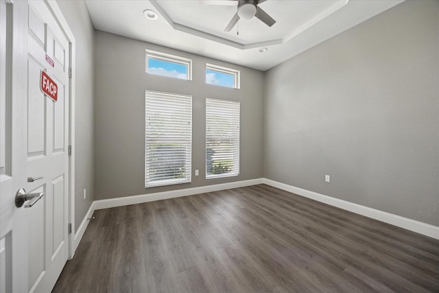 3001 Hurstview Dr, Hurst, TX 76054 - empty room featuring ceiling fan, a raised ceiling, dark wood-type flooring, and baseboards