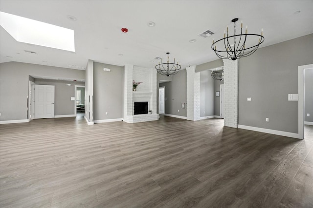 3001 Hurstview Dr, Hurst, TX 76054 - unfurnished living room featuring a chandelier, a brick fireplace, wood finished floors, and baseboards