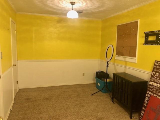 empty room with ornamental molding, a textured ceiling, and carpet
