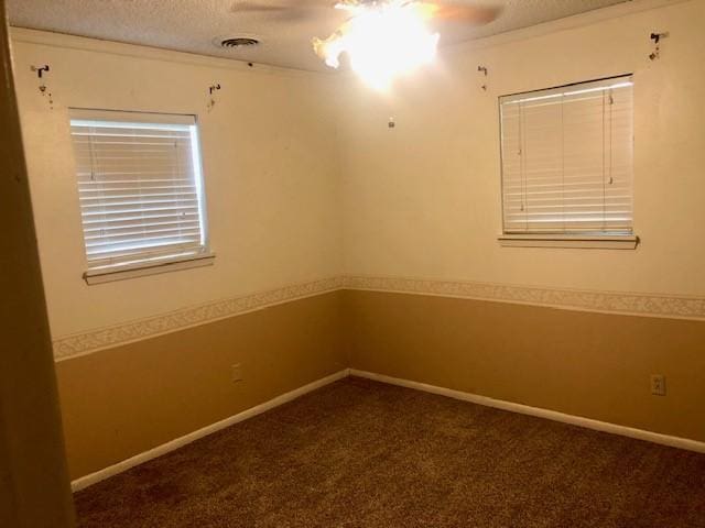 unfurnished room featuring carpet floors, baseboards, a ceiling fan, and a textured ceiling