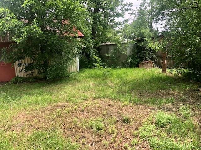 view of yard with fence and an outdoor structure