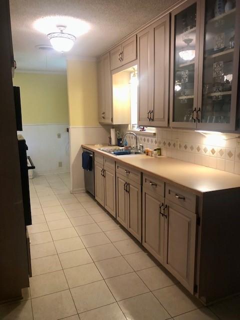 kitchen featuring light countertops, light tile patterned flooring, and a sink