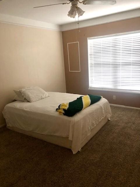 carpeted bedroom featuring baseboards and ceiling fan