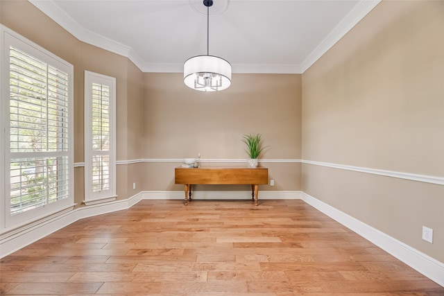 dining area with plenty of natural light, ornamental molding, light wood-style flooring, and a chandelier