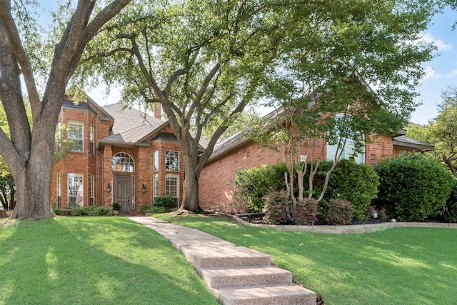 traditional-style home with a front yard and brick siding