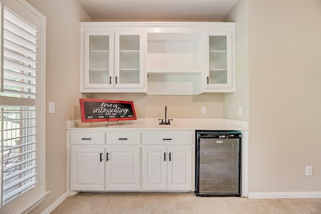 bar with wine cooler, baseboards, wet bar, and a sink