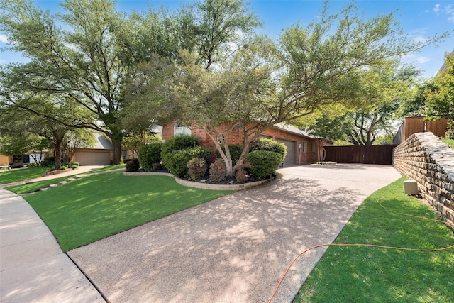 view of front of house with fence, concrete driveway, a garage, and a front yard