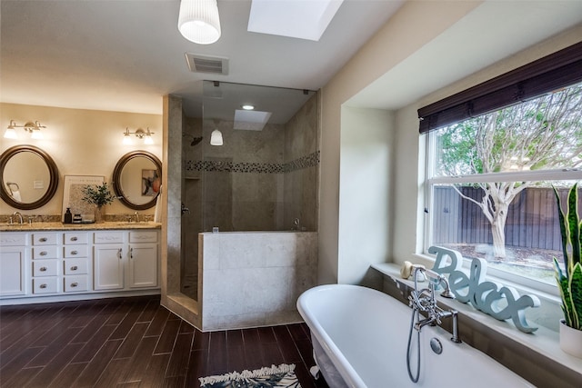 full bathroom with walk in shower, visible vents, a sink, and a freestanding bath