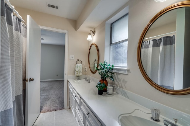 full bath with a sink, tile patterned flooring, double vanity, and visible vents